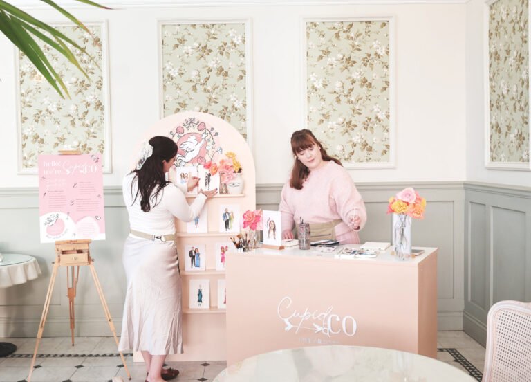Cupid & Co art cart with live wedding illustrations on display and two artists at work